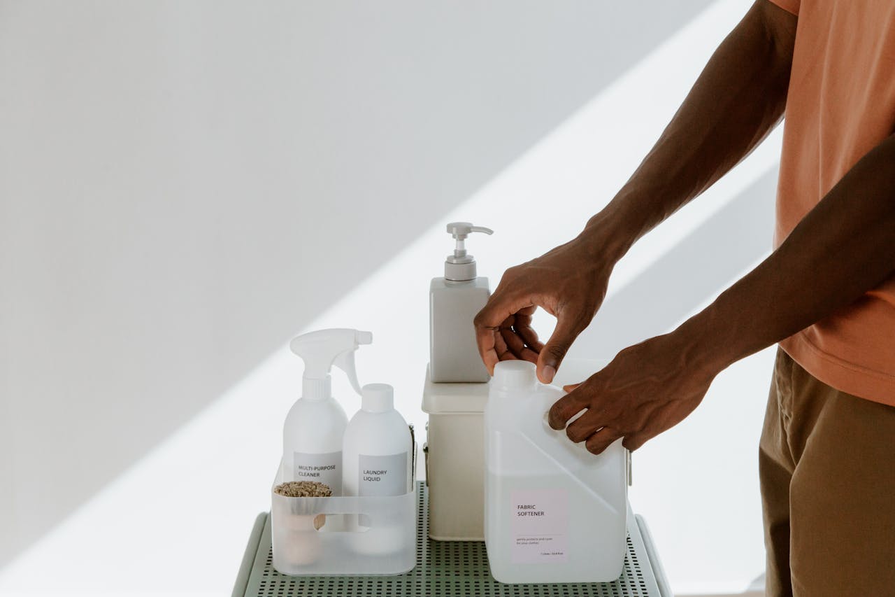 Man arranging cleaning products on a shelf, highlighting tidiness and organization.